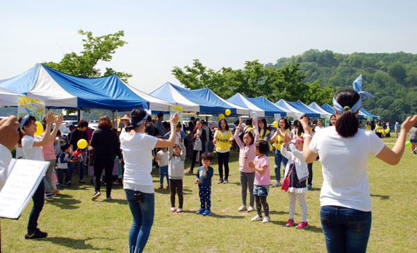 공주 민주단체협의회가 행사를 하는 금강 둔치공원에서 엄마들의 몸짓을 따라 동요 부르기가 진행 중이다.