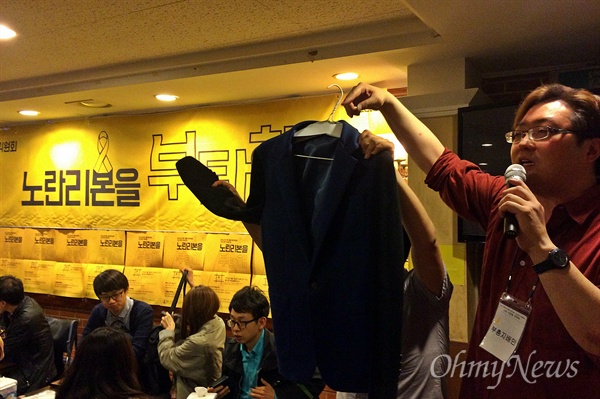 후원주점에서 진행된 경매에서 김덕진 위원회 운영위원장이 방송인 김제동씨의 재킷을 소개하고 있다. 
