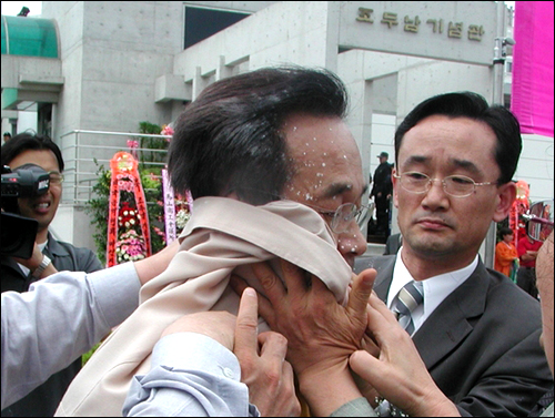 2003년 5월 조두남기념관 개관식에서 황철곤 마산시장이 시민단체 회원들에 의해 밀가루를 뒤집어 쓴 모습.