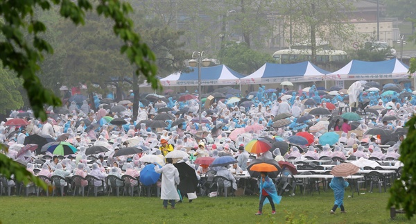 지난 6일 오전 서울시 용산구 용산가족공원에서 열린 제 44회 어버이날 기념행사에 참석한 어르신들이 빗속에서 점심을 먹고 있다.