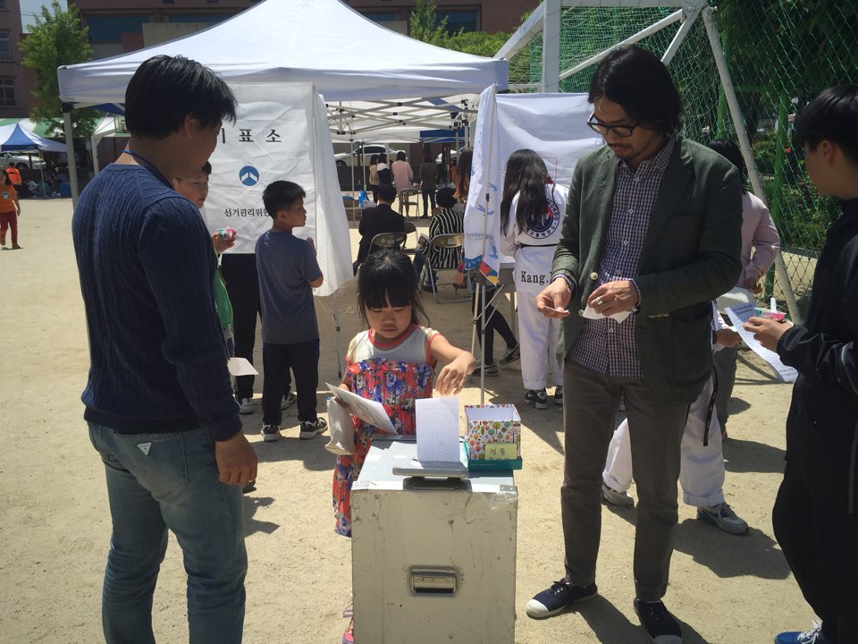 한 어린이가 그림그리기대회 투표에 참여하고 있다.