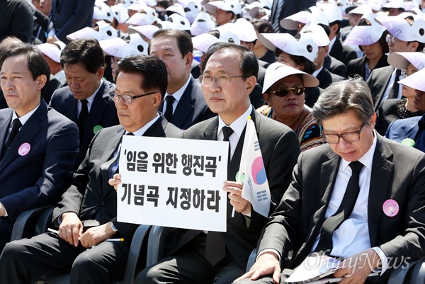 '임을 위한 행진곡' 기념곡 지정 촉구하는 노회찬 18일 오전 광주광역시 국립 5.18민주묘지에서 열린 '제36주년 5.18민주화운동 기념식'에서 황교안 국무총리가 기념사를 하는 동안 노회찬 정의당 당선인이 '임을 위한 행진곡 기념곡 지정하라'는 손 피켓을 들고 있다.