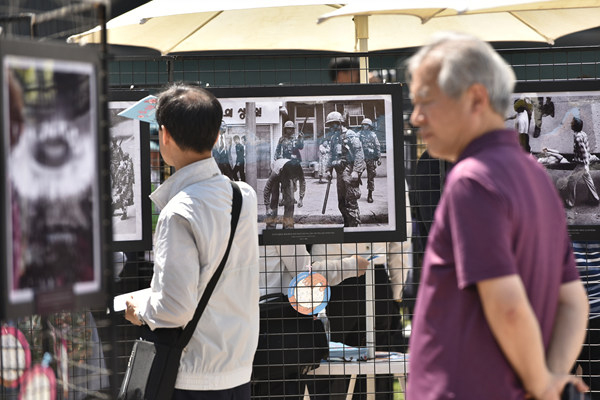 시민들이 18일 오전 서울광장에서 열린 5·18민주화운동 제36주년기념 서울행사장 주변에 전시되어 있는 5.18 항쟁 당시의 사진들을 바라보고 있다.