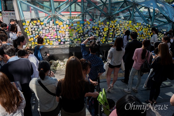 지난 5월 18일 오후 서울 강남역 10번 출구에는 지난 17일 새벽 노래방 화장실에서 발생한 '강남역 살인' 피해 여성을 추모하는 인파가 몰리고 있다. 추모를 위해 강남역을 찾은 시민들은 추모의 글을 적은 메모지를 붙히거나 헌화를 했다.