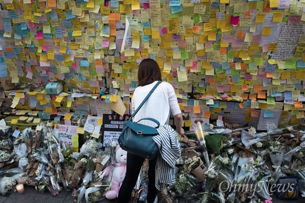 지난 5월 19일 서울 강남역 10번 출구에서 강남역 살인사건 피해자를 추모하는 한 시민이 추모 쪽지를 보고 있다.