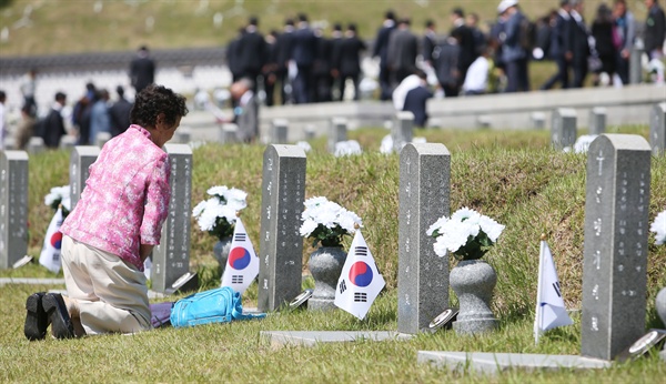 18일 오전 광주 북구 운정동 국립 5·18민주묘지에서 열린 제36주년 5·18 광주민주화운동기념식을 찾은 한 유족이 묘 앞에서 생각에 잠겨 있다.