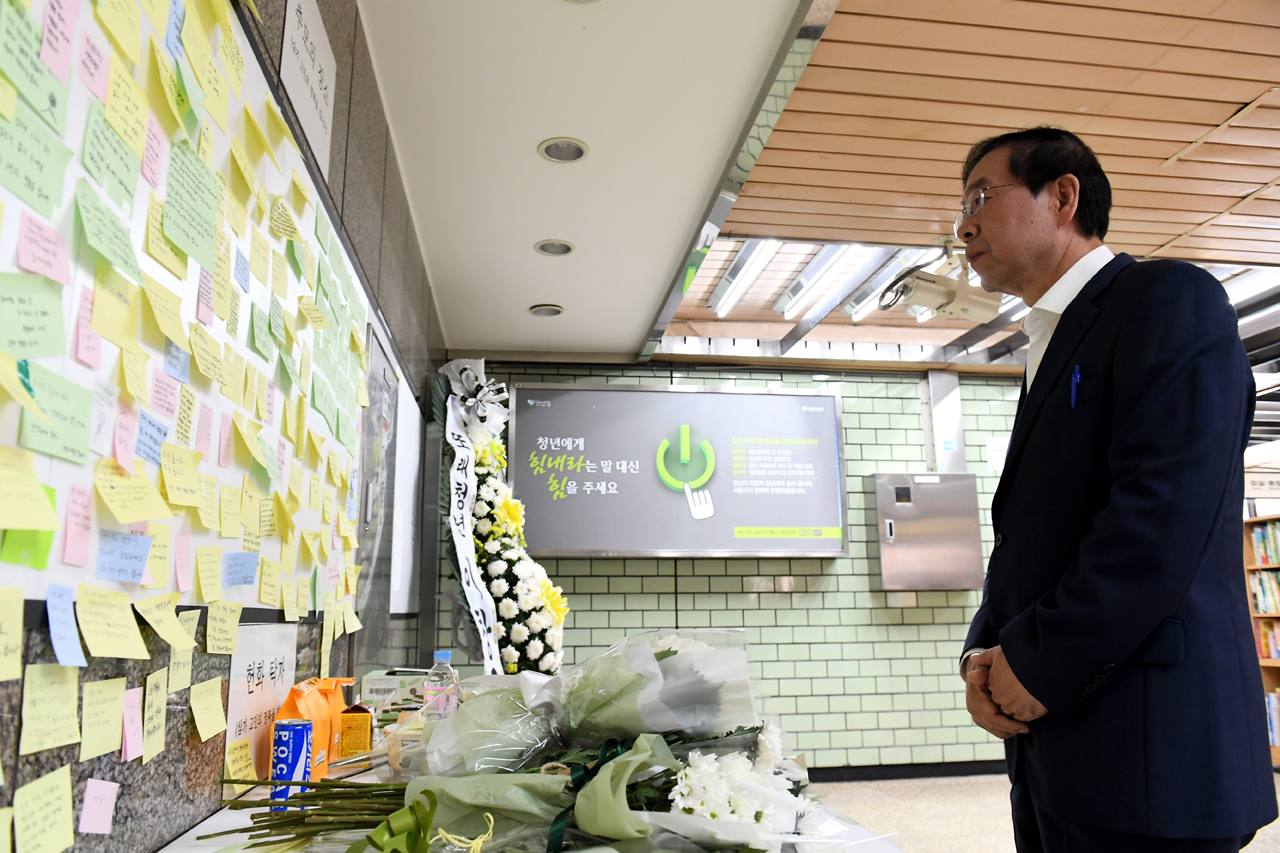 지난해 5월 31일 박원순 서울시장이 스크린도어 사고 현장인 구의역을 방문해 역구내에 설치되어 있는 추모공간을 찾아 고인을 추모하고 있다.