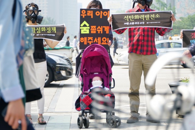 지난 27일 오전 서울 광화문광장에서 열린 '미세먼지 근본 대책 촉구 시민 캠페인'에서 서울환경운동연합 회원들이 방독면을 쓰고 '우리 아이 숨 좀 쉬게 해주세요' 퍼포먼스를 하고 있다.