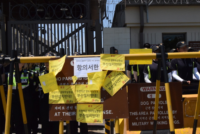  항의서한과 실험실 설치반대 경고문이 부착된 미군기지 정문 앞 표지판