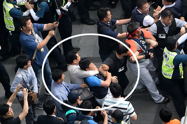  '기아자동차 사내하청 비정규직 전원의 정규직 전환'을 요구하며 서울 중구 옛 국가인권위원회 옥상 광고탑에서 고공농성을 벌인 기아자동차 사내하청 비정규직 노동자 최정명·한규협씨가 농성시작 363일만인 8일 오후 농성을 풀고 지상으로 내려온 가운데 경찰이 이들 곁으로 다가가던 한 노조원의 목을 뒤에서 조르고 있다.  