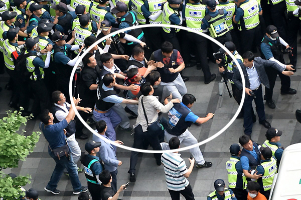 '기아자동차 사내하청 비정규직 전원의 정규직 전환'을 요구하며 서울 중구 옛 국가인권위원회 옥상 광고탑에서 고공농성을 벌인 기아자동차 사내하청 비정규직 노동자 최정명·한규협씨가 농성시작 363일만인 지난 6월 8일 오후 농성을 풀고 지상으로 내려온 가운데 경찰이 농성자 중 한 명인 한규협씨를 구급차에 태우기 위해 강제로 끌고 가고 있다.  