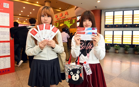  가오카오를 마친 두 여학생이 티켓을 보여주고 있다