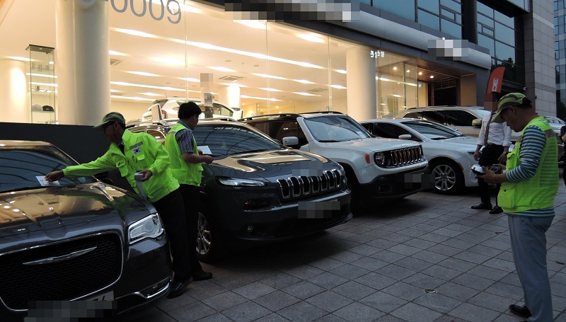 강남구청 직원들이 보도 위에 불법으로 주정차된 차량에 대해 단속을 펼치고 있다.