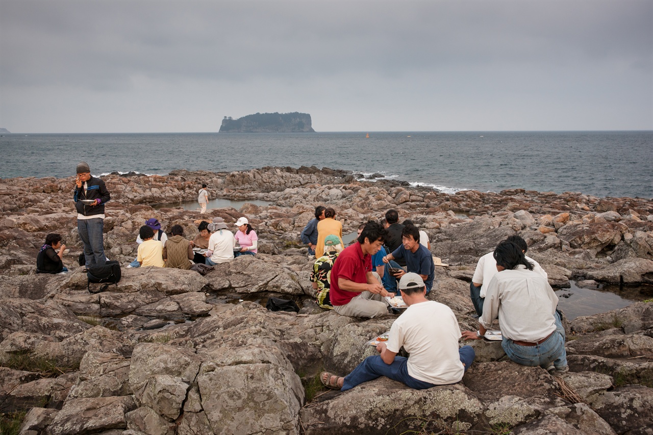 2011년 구럼비 바위 위에 둘러 앉아 밥을 먹는 사람들