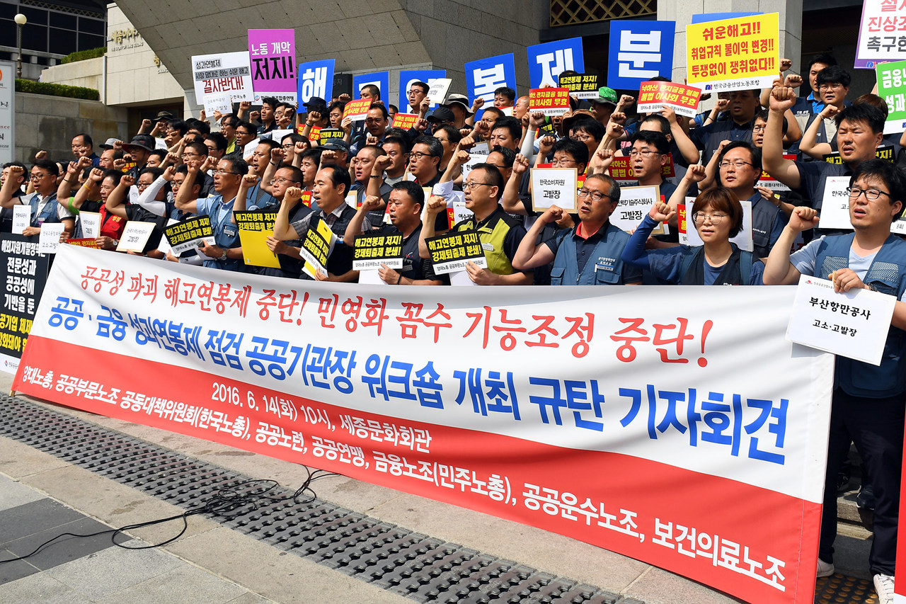  민주노총과 한국노총 조합원들이 14일 오전 서울 종로구 세종문화회관 앞에서 박근혜 대통령 주관으로 이날 열리는 성과연봉 임금체계 개편 등을 논의하는 공공·금융 성과연봉제 점검 공공기관장 워크숍 규탄 기자회견을 열어 공동고소고발 계획 발표하고 "공공성 파괴 해고 연봉제 중단!" 등의 구호를 외치고 있다.