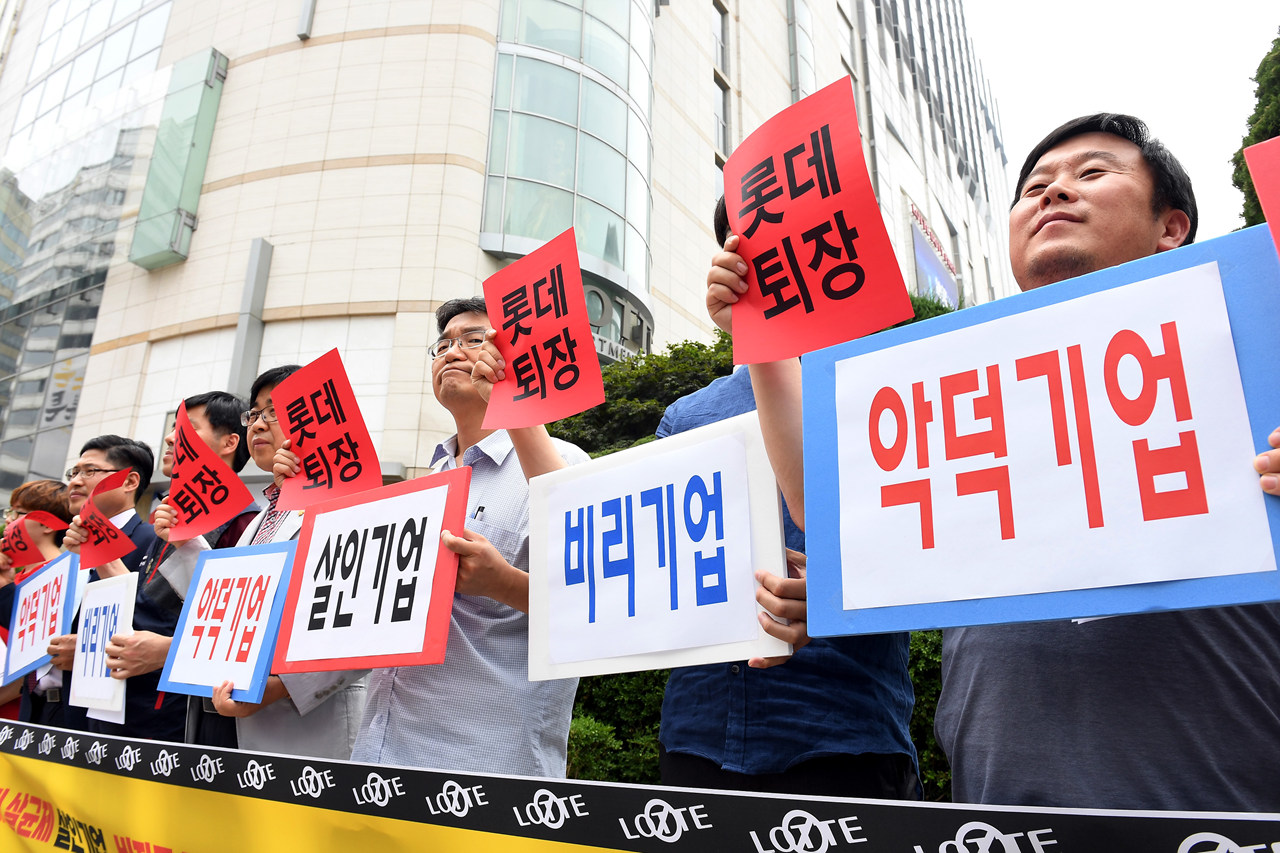  14일 오후 서울 중구 소공동 롯데본사 앞에서 열린 '롯데재벌에 분노한 중소상인 단체들과 시민들의 공동 기자회견'에서 전국유통상인연합회, 경제민주화전국네트워크 등 단체 회원들이 롯데그룹을 규탄하는 피켓을 들어 보이고 있다.