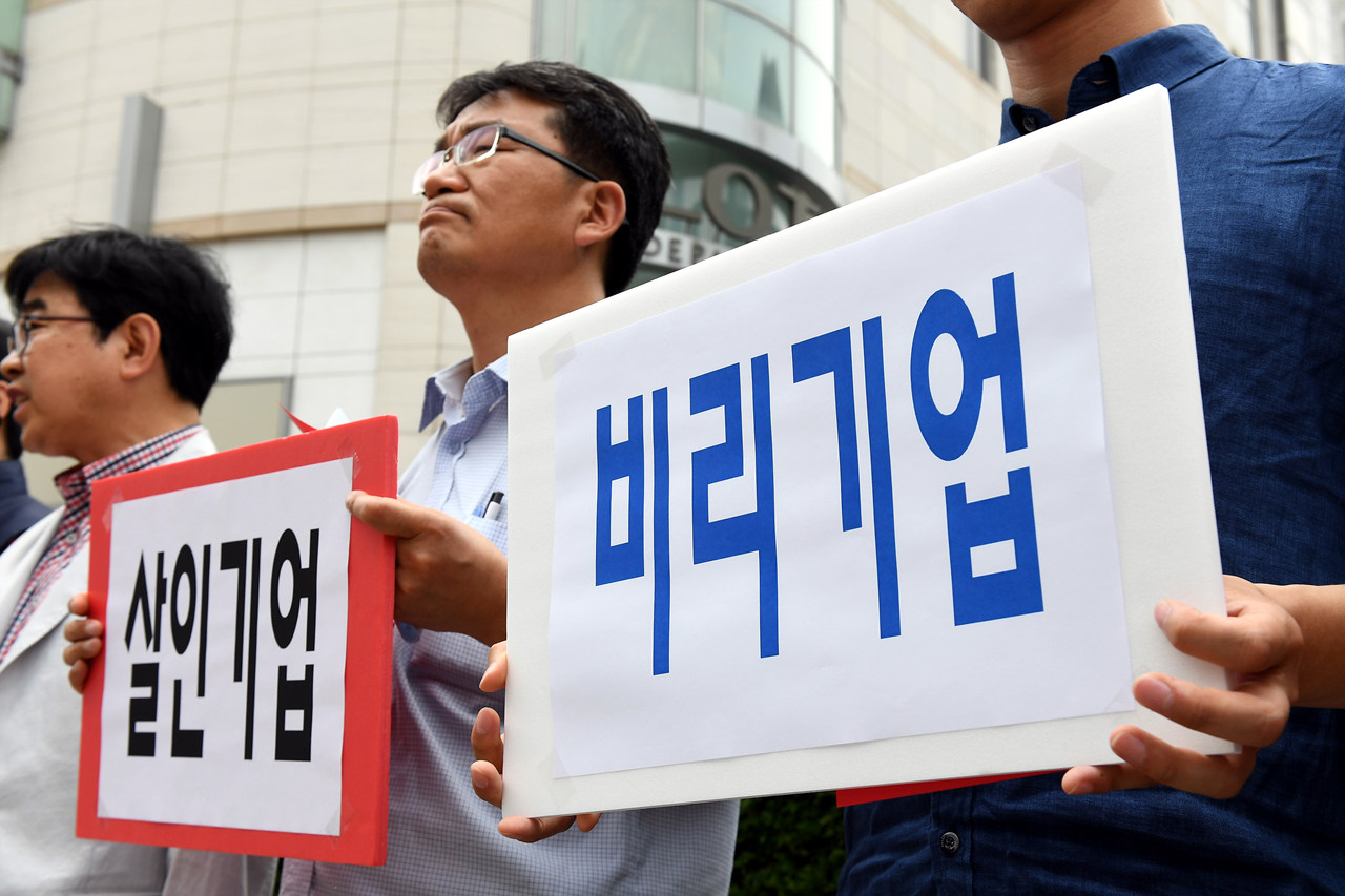  14일 오후 서울 중구 소공동 롯데본사 앞에서 열린 '롯데재벌에 분노한 중소상인 단체들과 시민들의 공동 기자회견'에서 전국유통상인연합회, 경제민주화전국네트워크 등 단체 회원들이 롯데그룹을 규탄하는 피켓을 들어 보이고 있다.