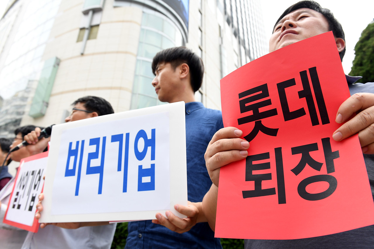  14일 오후 서울 중구 소공동 롯데본사 앞에서 열린 '롯데재벌에 분노한 중소상인 단체들과 시민들의 공동 기자회견'에서 전국유통상인연합회, 경제민주화전국네트워크 등 단체 회원들이 롯데그룹을 규탄하는 피켓을 들어 보이고 있다.