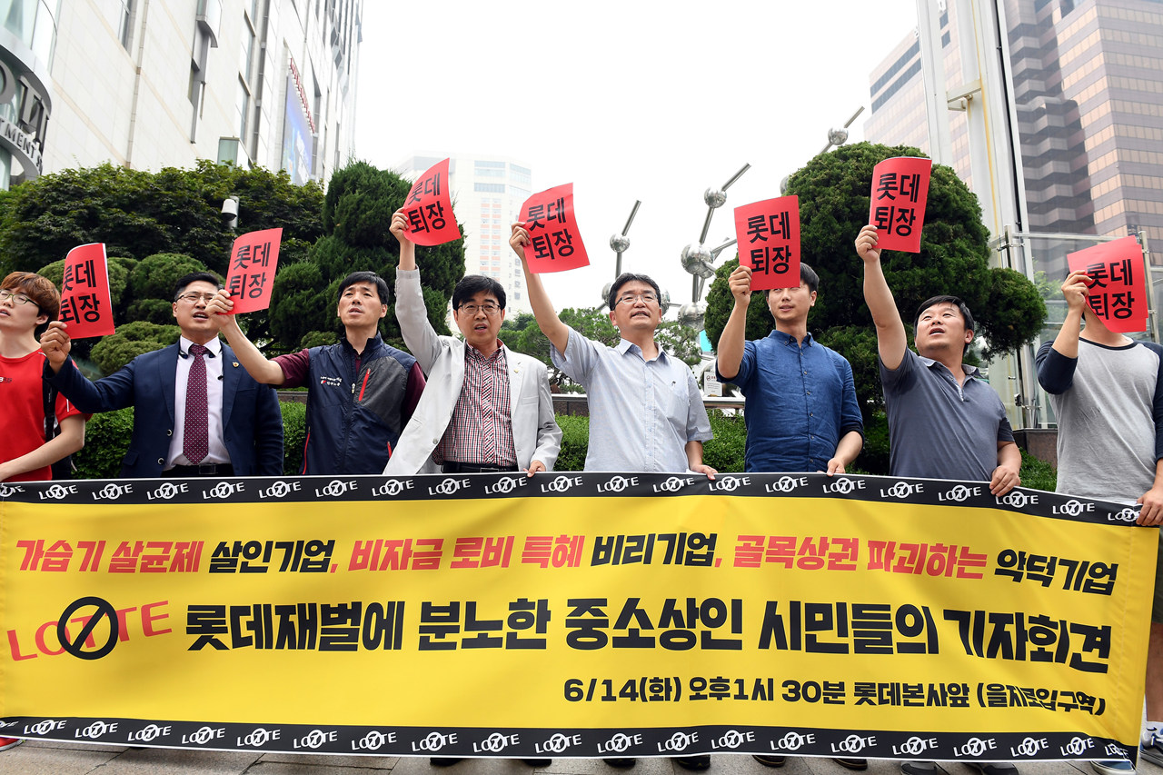  14일 오후 서울 중구 소공동 롯데본사 앞에서 열린 '롯데재벌에 분노한 중소상인 단체들과 시민들의 공동 기자회견'에서 전국유통상인연합회, 경제민주화전국네트워크 등 단체 회원들이 롯데그룹을 규탄하는 구호를 외치고 있다.