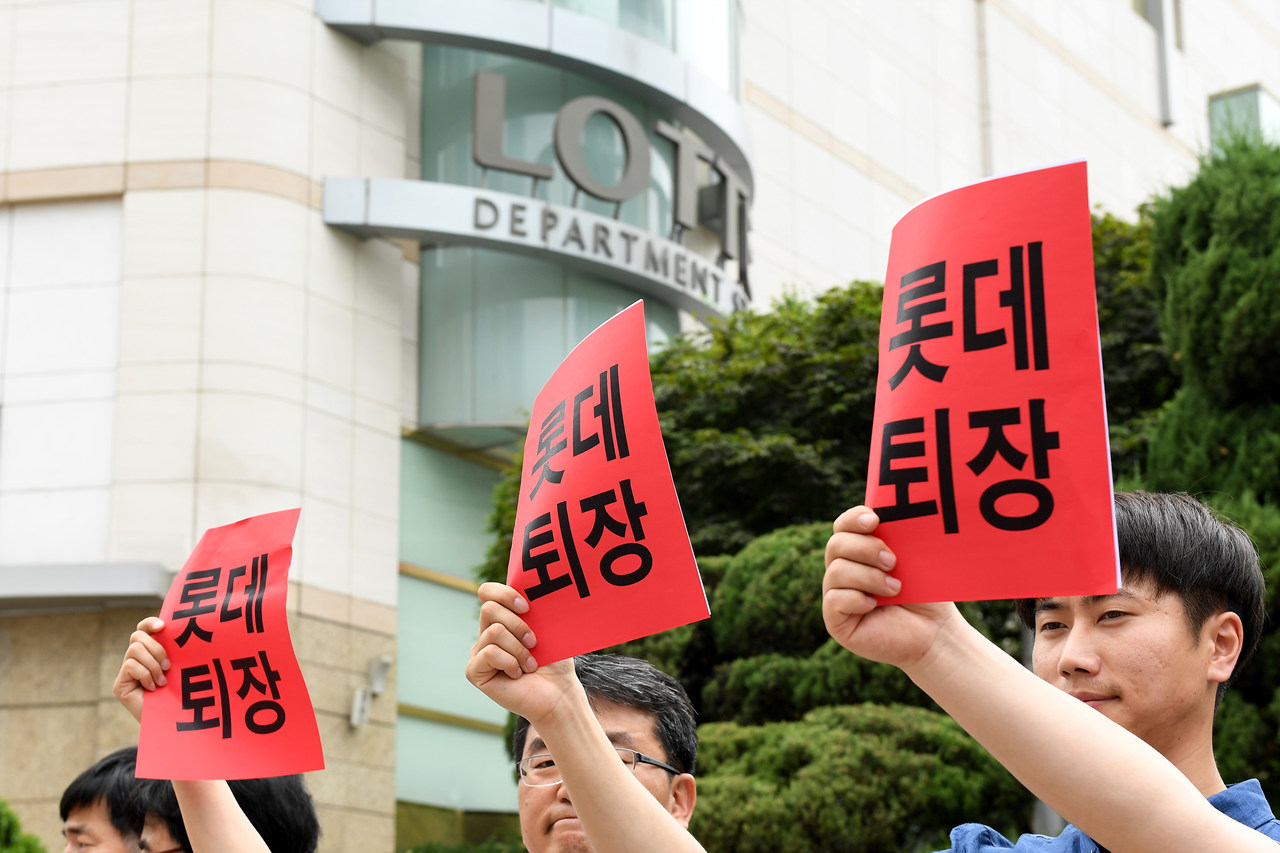  14일 오후 서울 중구 소공동 롯데본사 앞에서 열린 '롯데재벌에 분노한 중소상인 단체들과 시민들의 공동 기자회견'에서 전국유통상인연합회, 경제민주화전국네트워크 등 단체 회원들이 롯데그룹을 규탄하는 피켓을 들어 보이고 있다.