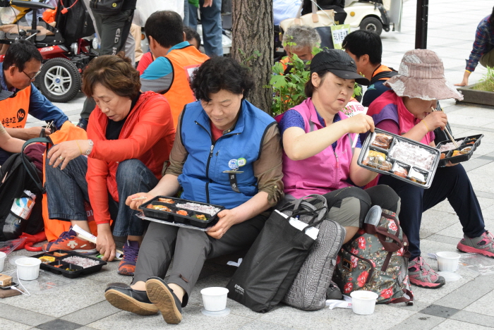 11:30경 범냇골 삼성생명 건물 앞에 도착한 참가자들이 점심으로 도시락을 먹고 있다.