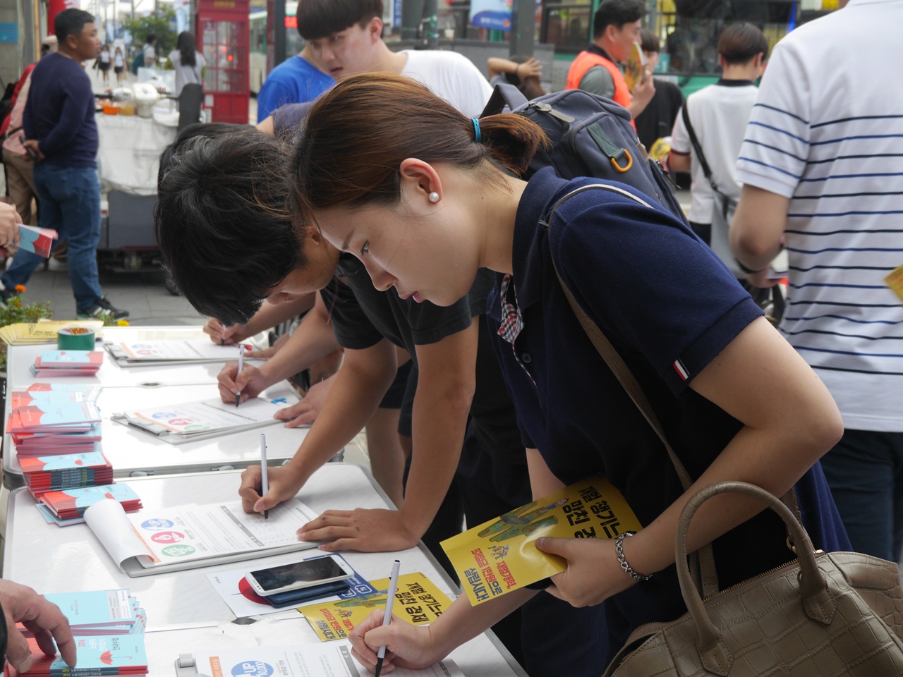 6월 14일 안성시 광신사거리 인근을 지나던 시민들이 최저임금 1만원 서명운동 동참하고 있다. 