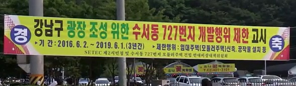  수서역 사거리에 수서동 727번지 개발행위 제한 고시를 축하하는 현수막이 걸려있다.