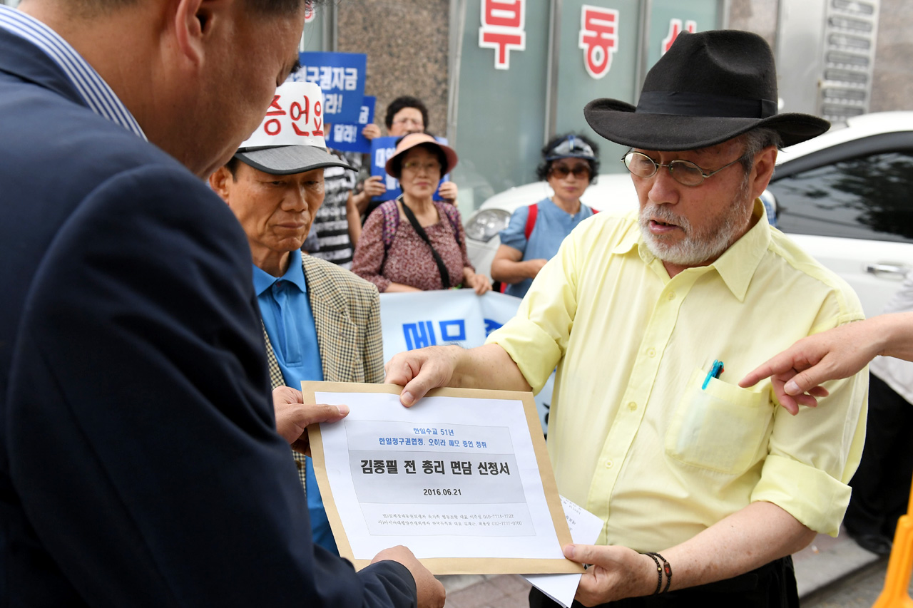  일제 강제동원희생자유가족협동조합 및 아시아태평양 전쟁희생자 한국유족회 관계자들이 21일 오후 서울 중구 신당동 김종필 전 총리 자택 앞에서 '한일협정 당시 일본외상 오히라 와 메모로 합의한 역사의 진실을 밝힐것'을 촉구하는 기자회견을 가진후 경촬 관계자를 통해 김종필 전 총리 면담 요청서를 전달하고 있다.