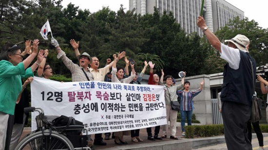  21일 중국 북한식당 종업원 탈북 여성 12명의 자진 귀순 여부를 확인하는 인신구제 심리가 열린 21일 서울중앙지법 앞에서 ‘대한민국 구국채널’ 회원 20여명이 민변 변호사들에게 욕지거리를 한 뒤 모여 "대한민국 만세"를 외치고 있다. 