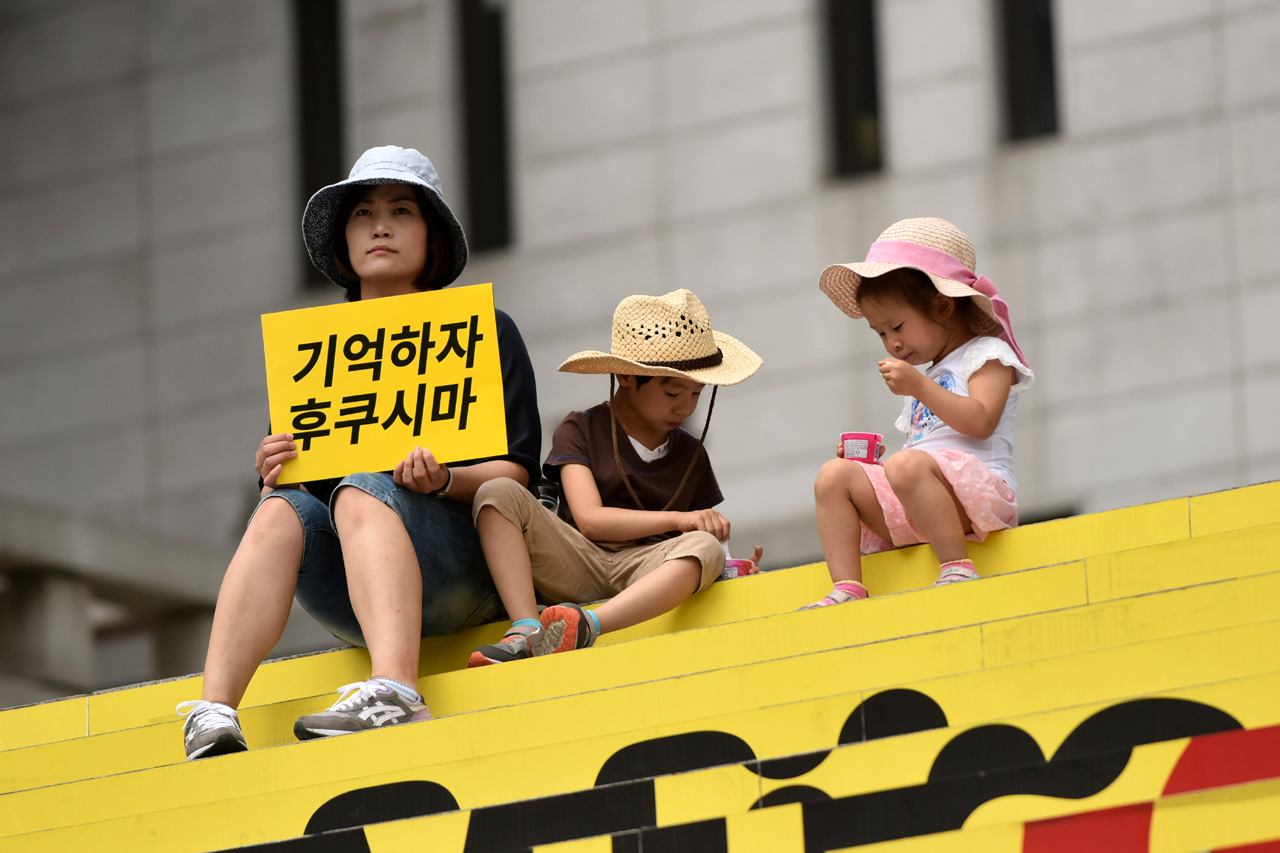  핵없는 사회를 위한 공동행동 등 시민단체 관계자들이 23일 오전 서울 광화문 세종문화회관 중앙계단 앞에서 '신고리 5,6호기 건설 반대 신규핵발전소 확대 중단 1,000인 선언행사'를 진행하고 있는 가운데 엄마와 함께 참가한 아이들이 아이스크림을 먹고 있다.