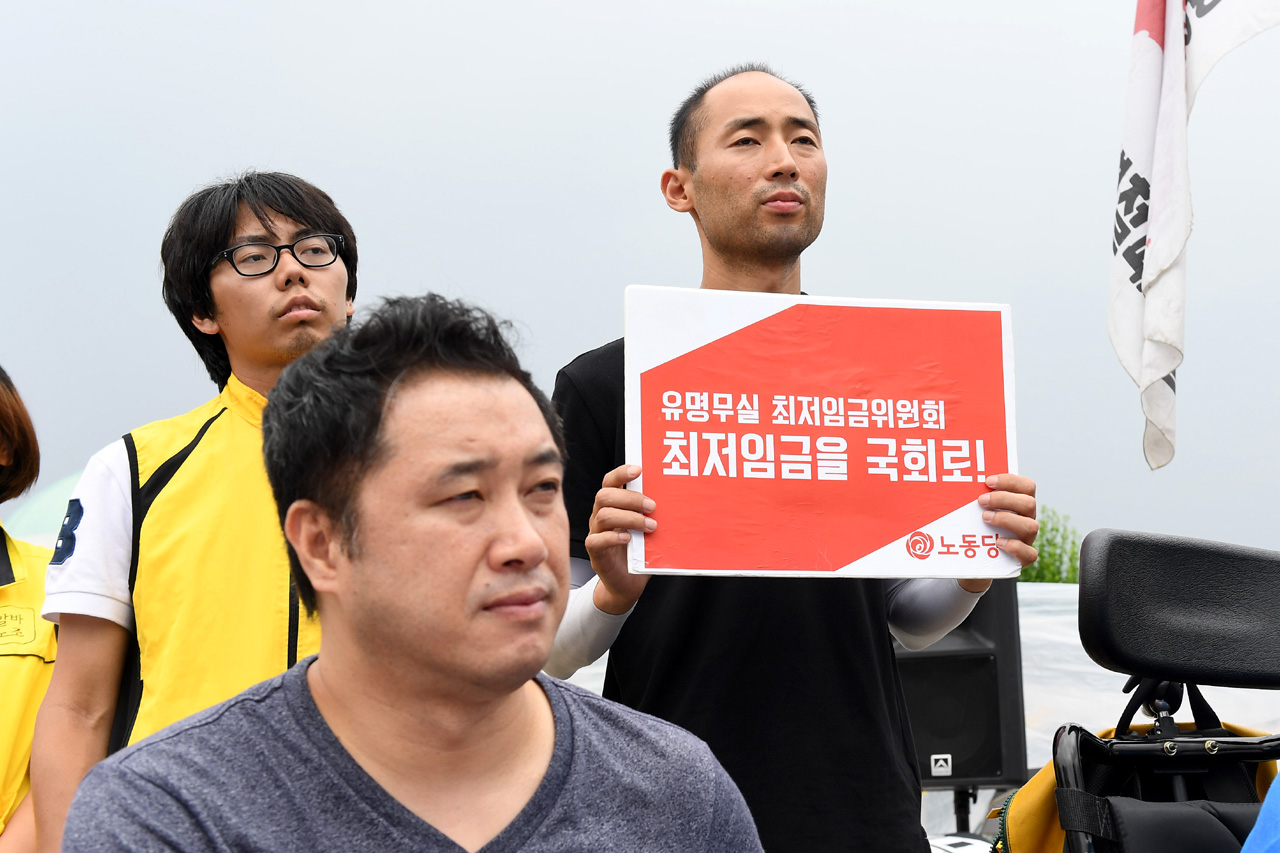  전국장애인차별철폐연대 등 장애인관련 단체 회원들이 24일 오후 서울 여의도 국회의사당 정문 앞에서는 '최저임금 1만원 인상'을 요구하며 이날로 4일째 단식농성을 벌이고 있는 노동당 구교현 대표를 지지하는 기자회견을 열고 있다.