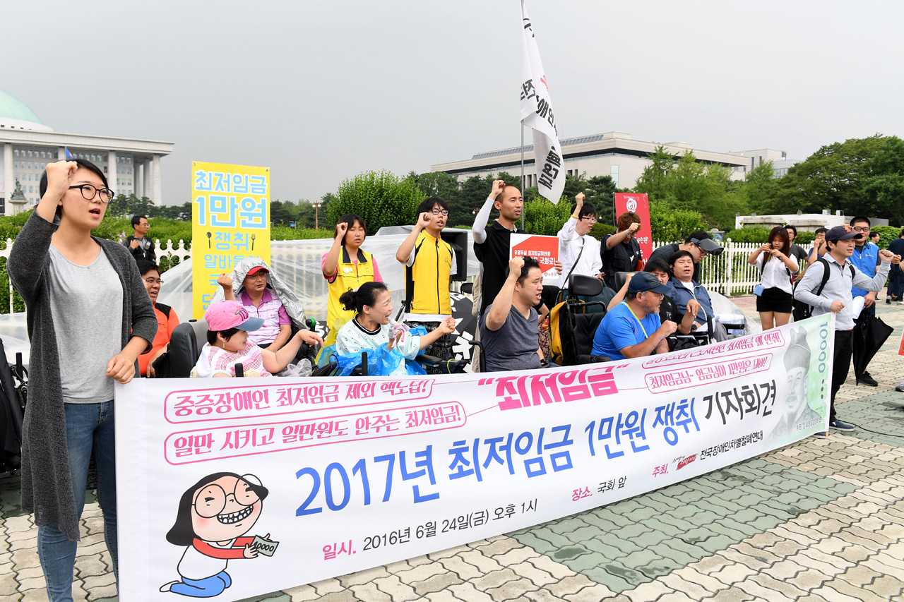  전국장애인차별철폐연대 등 장애인관련 단체 회원들이 24일 오후 서울 여의도 국회의사당 정문 앞에서는 '최저임금 1만원 인상'을 요구하며 이날로 4일째 단식농성을 벌이고 있는 노동당 구교현 대표를 지지하는 기자회견을 열고 있다.