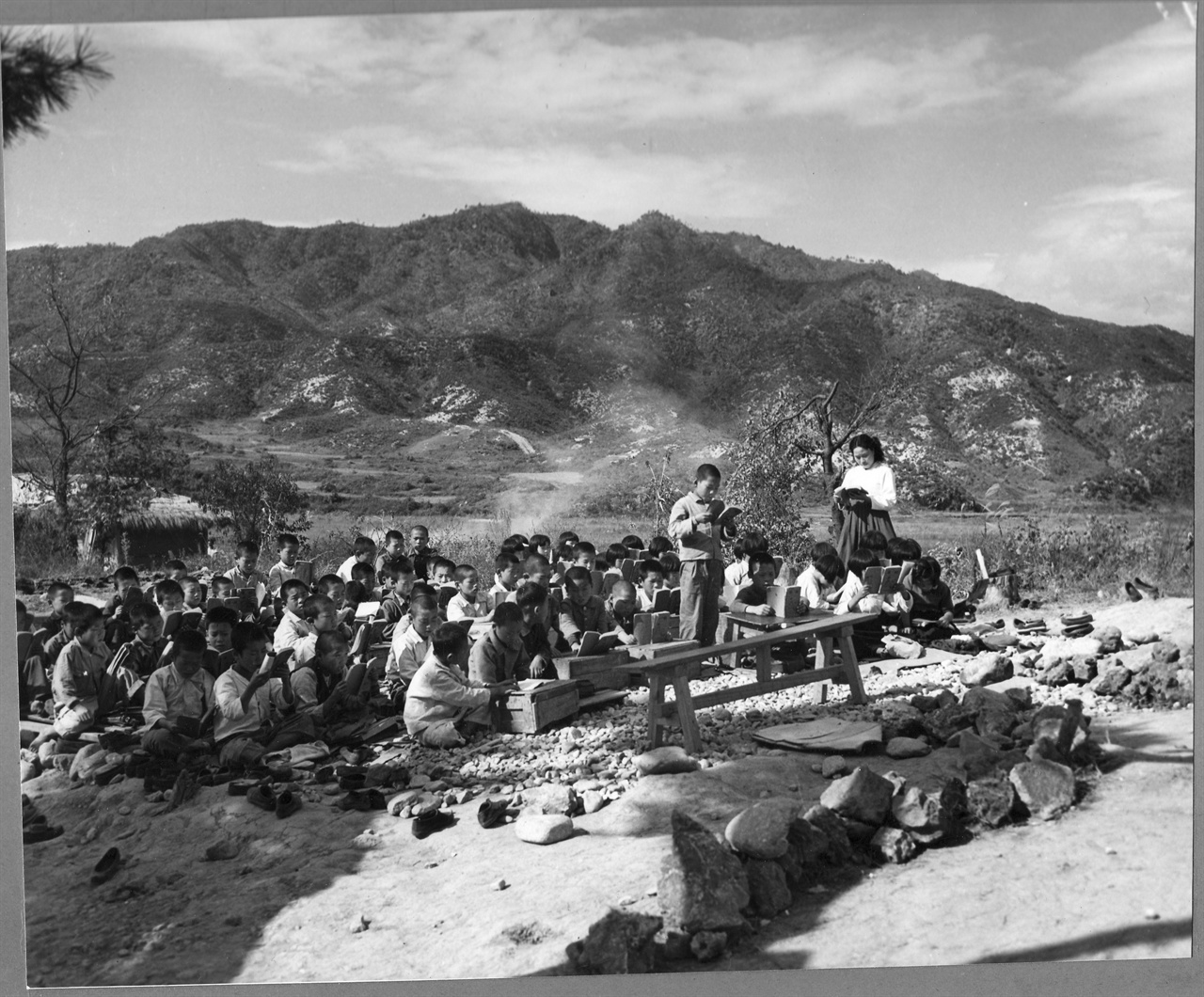  전란으로 학교 교실이 잿더미가 되자 불 탄 자리에서 수업을 하고 있다(1953. 10. 서울 근교).