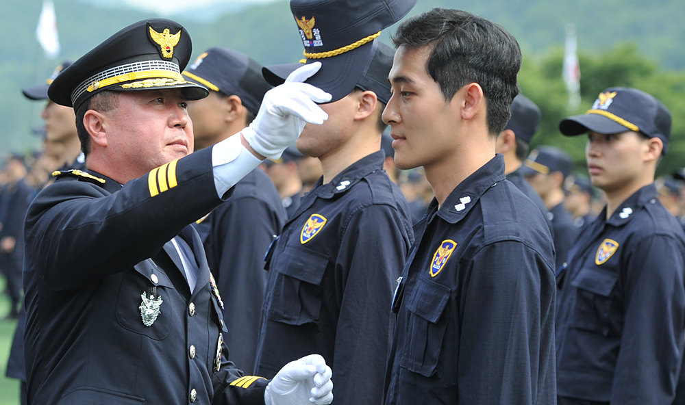 27일 중앙경찰학교에서 열린 신임경찰 289기 입교식에서 김양제 학교장이 예비 경찰의 모자를 확인한 후 씌워주고 있다.
