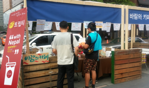 서울 청계광장에 마련된 트립티 부스에서 시민들이 커피를 주문하고 있다.