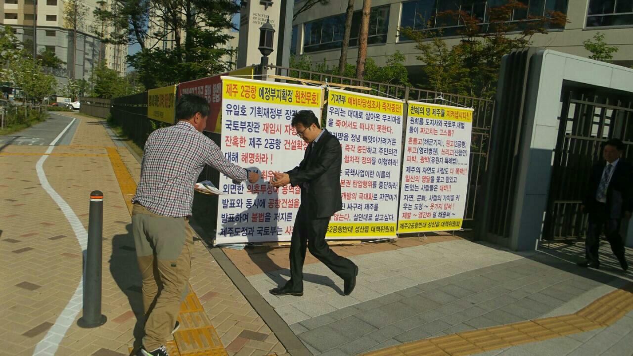 한국개발연구원 앞에서 신공항에 대한 문제제기를 하며 연구원 직원들에게 전단지를 나눠주고 있다
