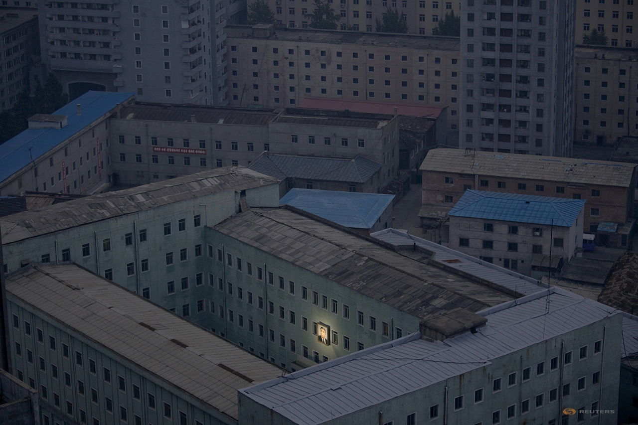  전력난으로 전기가 모두 나간 평양의 주거 단지에서 건물 외벽에 걸린 김일성 초상화만 홀로 조명을 받고 있다. 당시는 김정일 사망 두 달 전으로 북한 전력사정이 최악이었을 때다. Damir Sagolj /2011.10.5