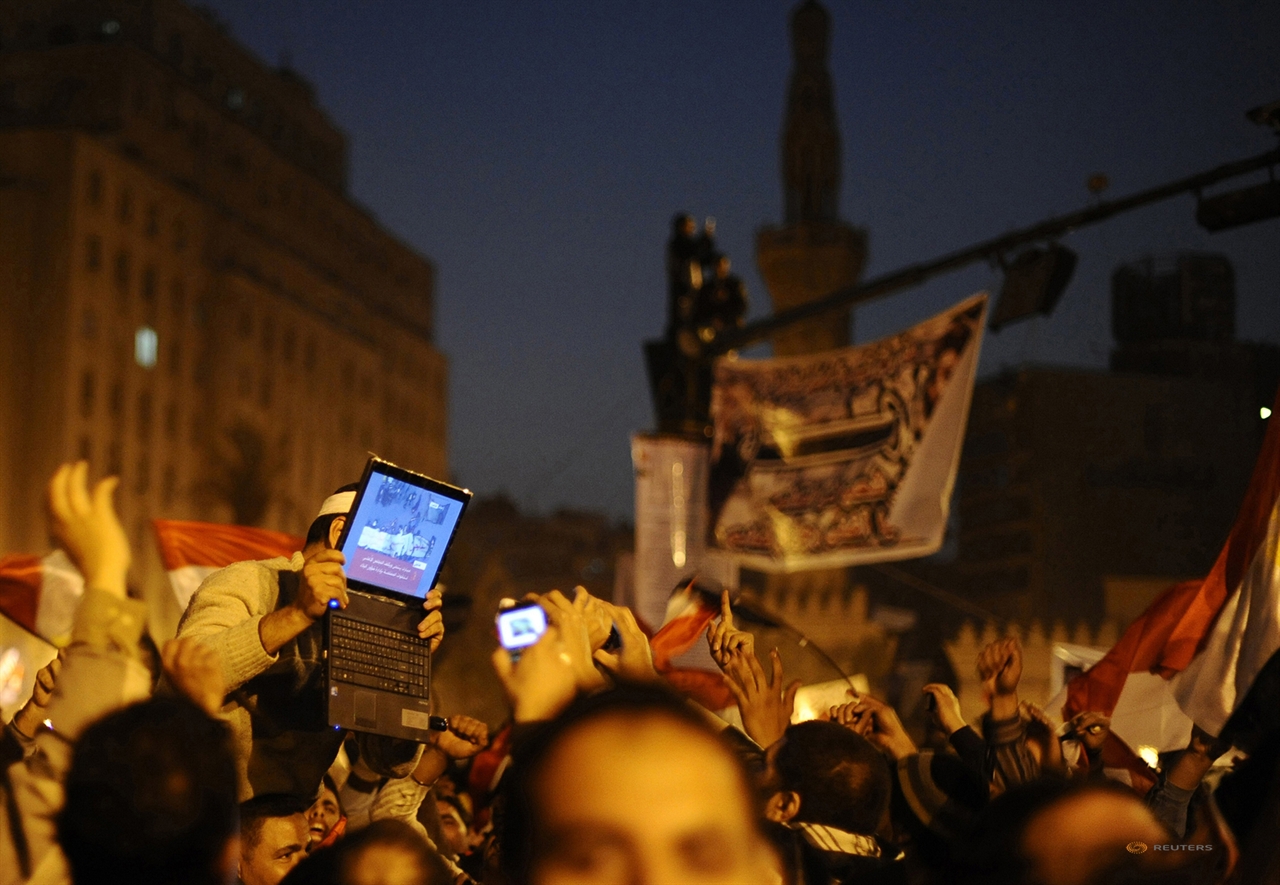  2011년 호시니 무바라크 이집트 대통령의 사임 이후 카이로 타흐리르 광장에서 반정부 지지 자가 노트북을 높이 들어 무바라크의 사임식 장면을 보여주고 있다. Dylan Martinez /2011.02.11