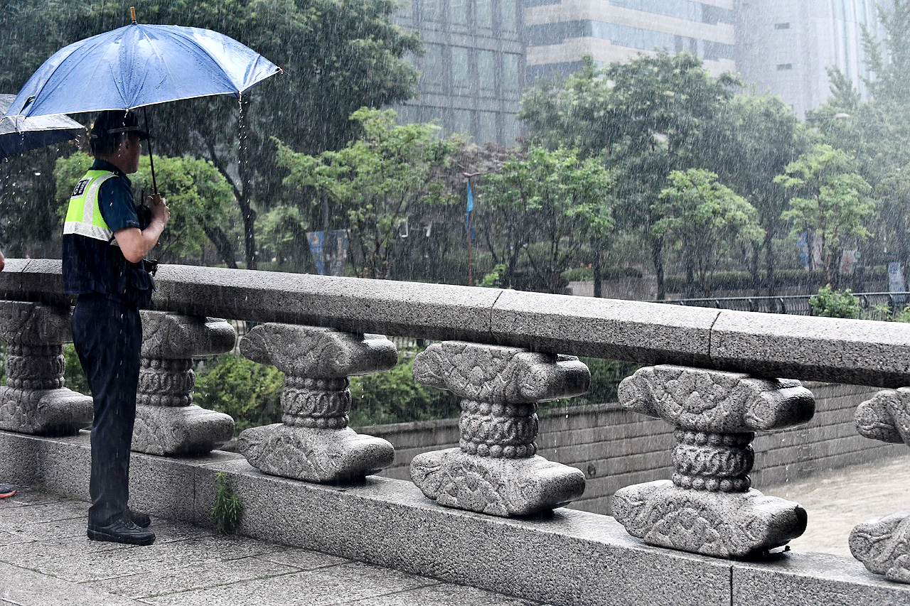 5일 오전 서울과 경기, 강원도 일부지역에 호우경보가 발효된 가운데 한 경찰관이 폭우로 인해 시민들의 출입이 통제된 청계천 일대를 살펴보고 있다.