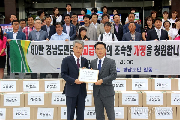  경상남도교육청과 경상남도학교운영위원회, 친환경무상급식지키지 경남운동본부는 경남도민 61만 8651명으로부터 받은 '학교급식법 개정 청원 서명지'를 6일 국회에 제출하기에 앞서, 5일 오후 경남도교육청 현관 앞에 쌓아 놓고 기자회견을 열면서 박종훈 교육감과 박덕만 협의회장이 청원서를 들어보이고 있다.