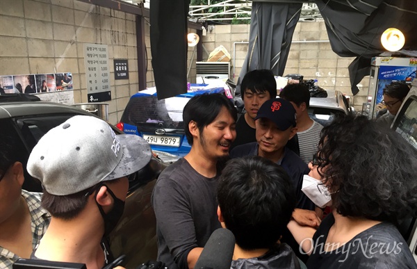 가수 리쌍 소유 건물에서 식당 우장창창을 운영해온 서윤수씨가 7일 강제 집행이 무산된 뒤 동료 상인들과 인사를 나누고 있다.