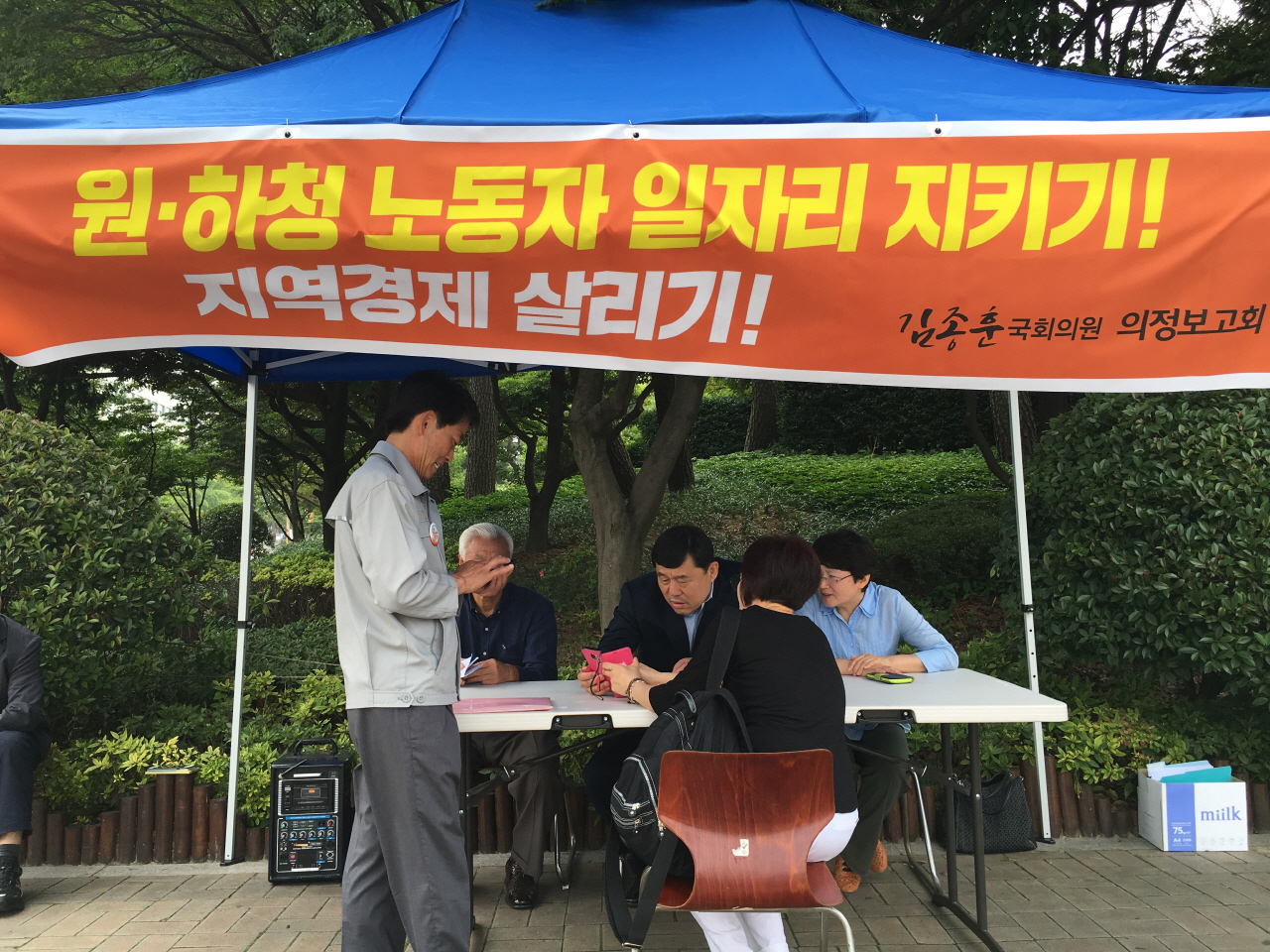  울산 동구 현대중공업 정문 앞에 마련된 이동사무소에서 김종훈 의원이 의정보고회를 열기전 지역상인과 상담하고 있다