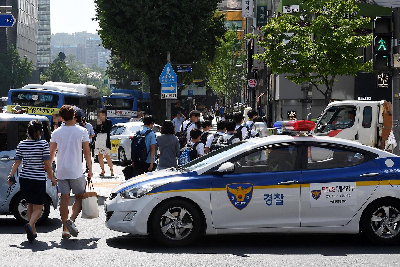 보행자 신호시 횡단보도에 정차한 순찰차 경찰 순찰차 한대가 6일 오후 광화문 광장인근 횡단보도에서 정지선을 넘어 진입해 정차하는 바람에 보행자들이 순찰차를 피해 횡단보도를 건너고 있다.