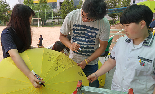 지난 13일 석남중학교에서 열린 ‘세월호 노란 우산 프로젝트’에 참가한 교사와 학생들이 노란우산에 세월호 추모 관련 그림을 그리고 있다. 