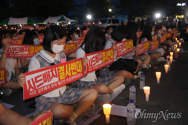  14일 오후 성주군청 앞마당에서 열린 사드배치 반대 촛불집회에 참가한 여학생들이 '사드배치 결사반대'가 쓰여진 현수막 천을 들어보이고 있다.