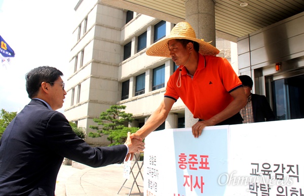 정의당 여영국 경남도의원이 홍준표 경남지사의 사퇴를 요구하며 17일로 엿새째 경남도의회 현관에서 단식농성하는 가운데, 더불어민주당 김경수 국회의원(김해을)이 격려방문 와서 악수하고 있다.