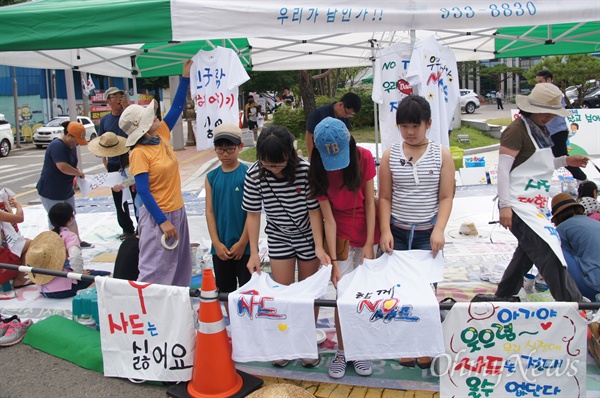   일요일인 17일 오전부터 성주군청 앞마당에서 아이들과 엄마들이 함께 '사드 반대' 티셔츠 글씨와 그림을 그리고 있다. 