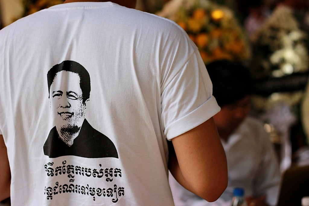 껨 레이의 얼굴이 그려진 티셔츠를 입은 시민. 여야를 가리지 않는 날카로운 비판과 정치평론으로 캄보디아 국민들의 사랑을 받았던 그에 대한 국민들의 추모열기를 보여준다.