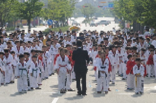 지난 18일 전북도청 앞에서 열린 '2017 무주 세계태권도선수권대회' 성공을 기원하는 행사를 앞두고 더위 속에서 힘겹게 기다리고 있는 초등학생들.