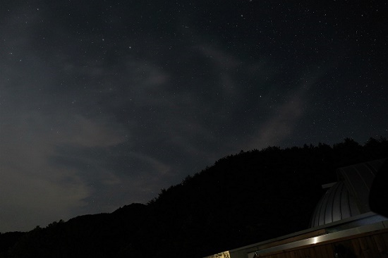 천문대 돔이 열리자 구름이 흐르는 하늘 사이로 별들의 무리가 나타났다.